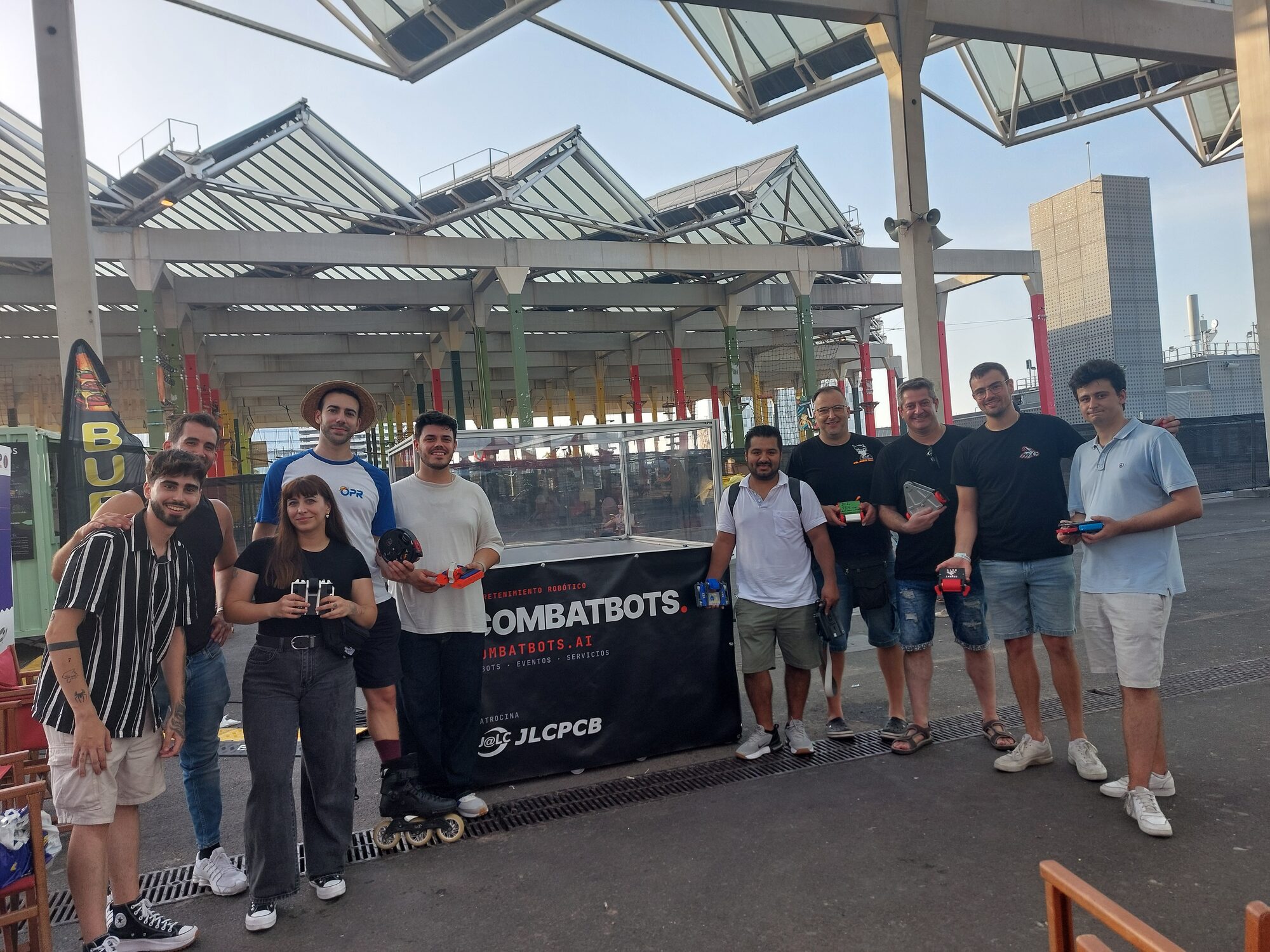 Los pilotos posan con sus robots delante de la lona de COMBATBOTS al final del sábado