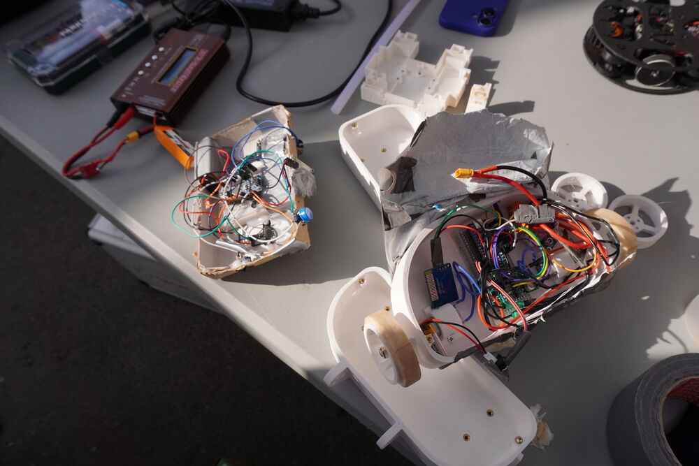 Un robot con la electrónica y el cableado a la vista, sobre la mesa del pit