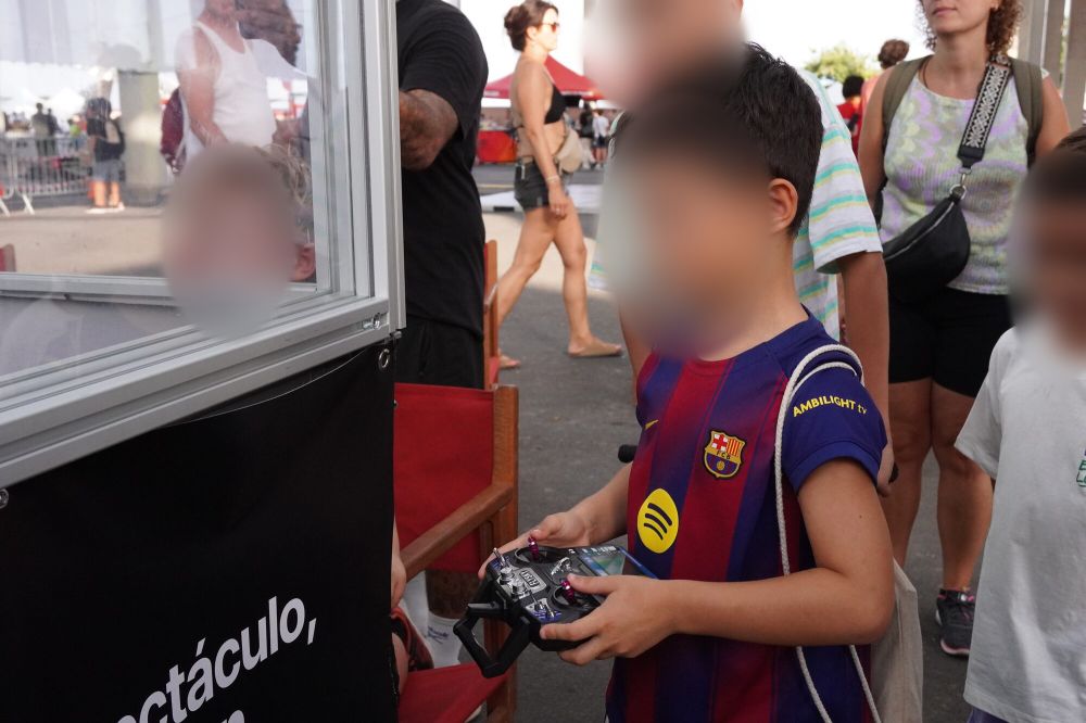 Un niño con camiseta de fútbol sostiene el mando junto a la arena