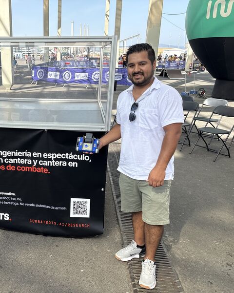 Cristian, con Vex, su robot de orugas azul, junto a la arena