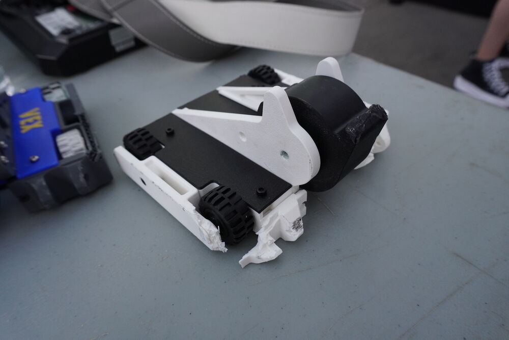 Un robot blanco y negro de perfil sobre la mesa del pit